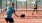 a person hitting a ball with a pickleball paddle to another person