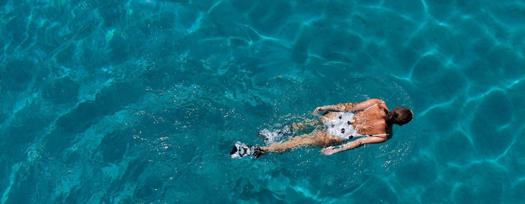 overhead shot of a woman swimming in a pool